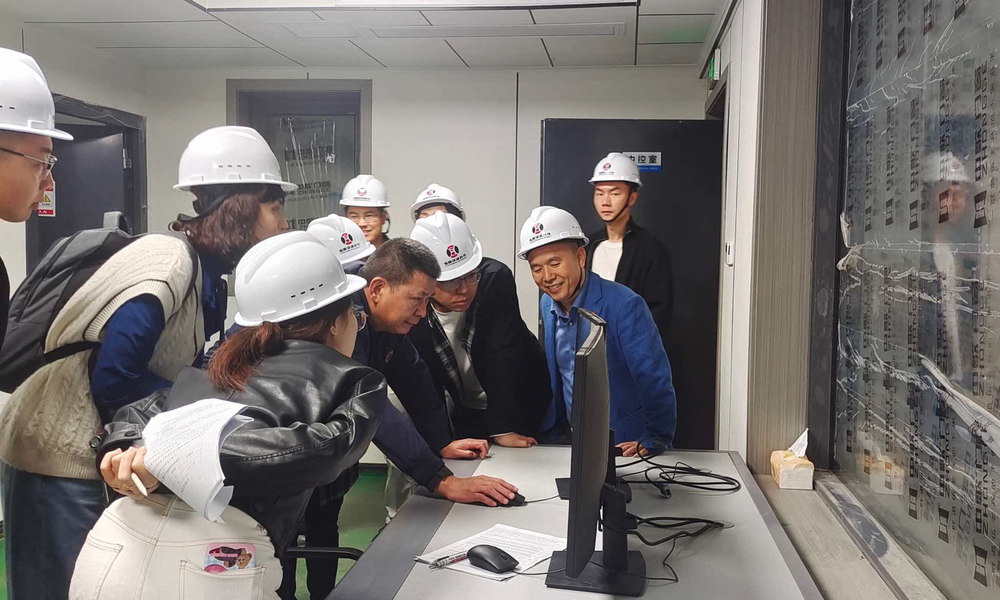 科研团队在中控室讨论生产工艺参数